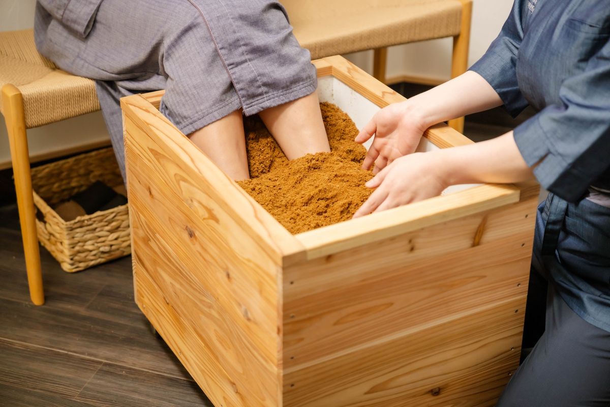 木桶の中で米ぬかとおが粉に足をうずめるところ